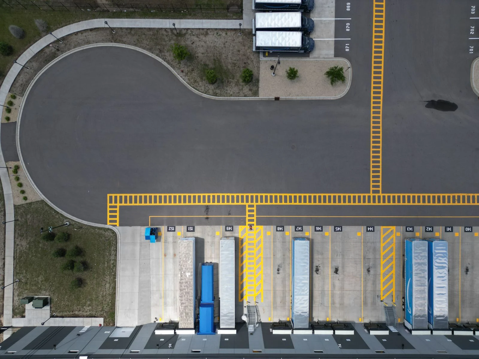 Illustrative stock aerial photograph of trucks and yellow markings around an industrial loading dock
